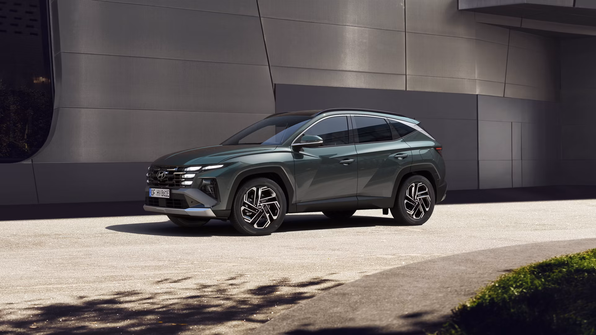 The Hyundai TUCSON Plug-in Hybrid parked next to a modern building.
